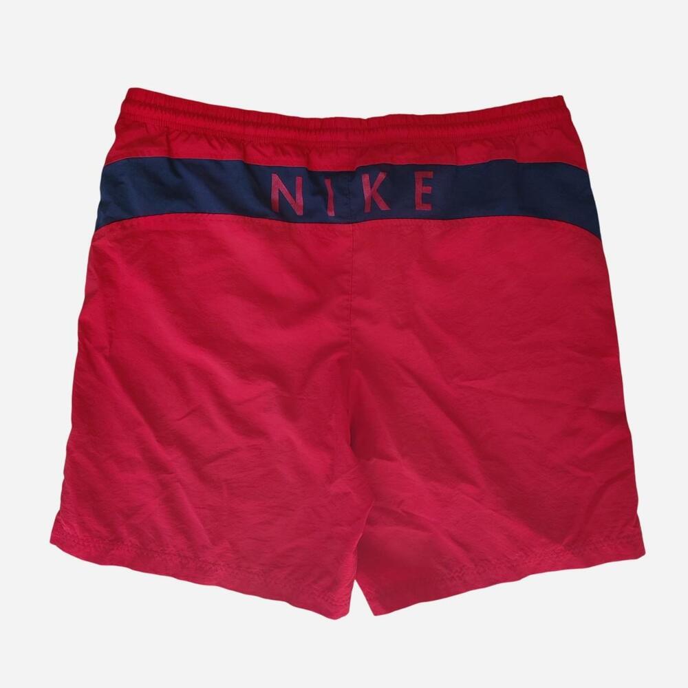 vintage Nike red swim shorts with navy blue stripe and vertical 'NIKE' text